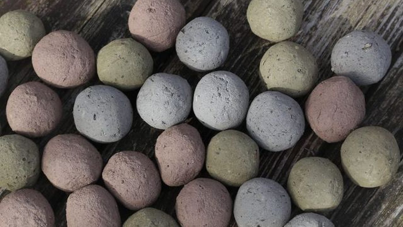Twenty-four loose seed bombs in earth tones, ready to be packed into an advent calendar