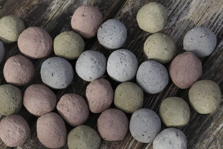 Vierundzwanzig lose Samenbomben in Erdtönen, bereit zum Abfüllen in einen Adventskalender